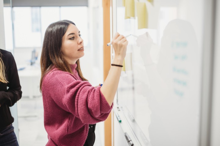 A person writing on a whiteboard