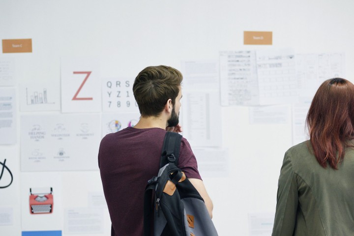 A person looking at a wall with papers